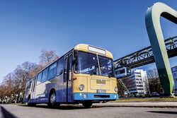 Der Oldtimerbus mit der Schwebebahn im Hintergrund