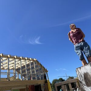 Holzskulptur vor Gebäude aus Holz