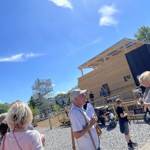 Besucher vor Gebäude in Holzbauweise